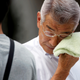 A businessman wipes his face while walking on a street during a heatwave in Tokyo, Japan July 23, 2018.